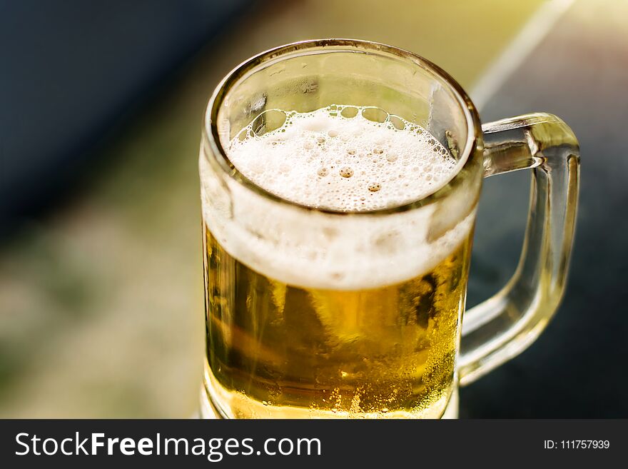 Drinking Beer in Summer Concept. Glass of Beer on Balcony. Warm Tone