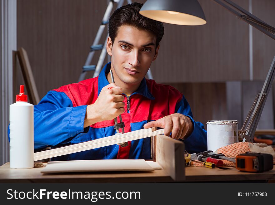 The young man gluing wood pieces together in diy concept