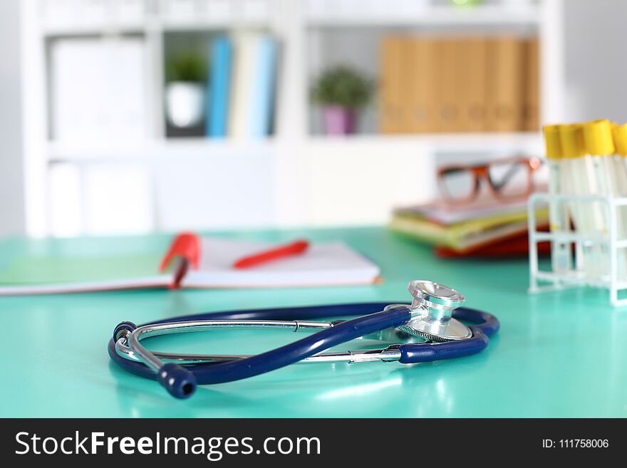 Doctor`s workspace working table with patient`s discharge blank paper form, medical prescription, stethoscope on desk