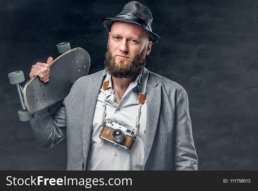 Bearded Male In A Suit And Holds Skateboard And Photo Camera.