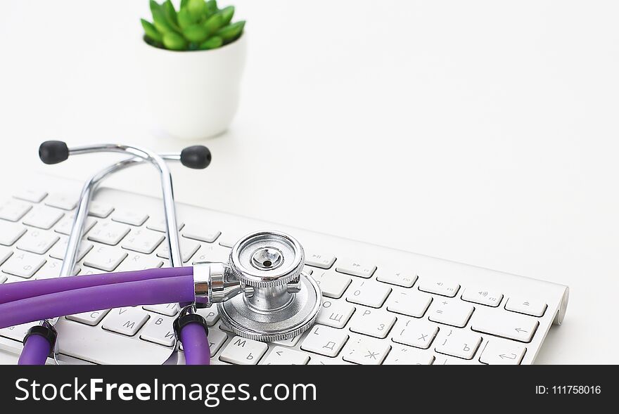 A stethoscope is on the keyboard of a computer