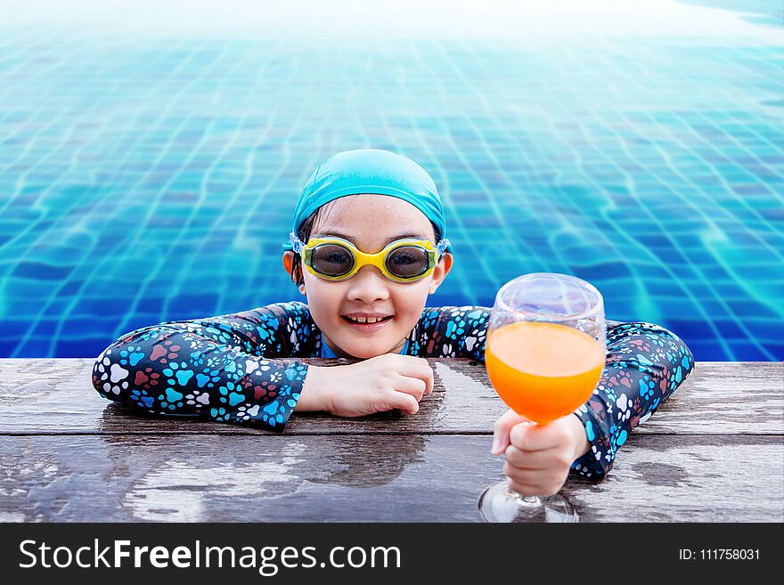 Happy Children at the Swimming Pool Side, Girl Relaxing with Summer Drink, Smile and Looking at Camera, Blue Water as background