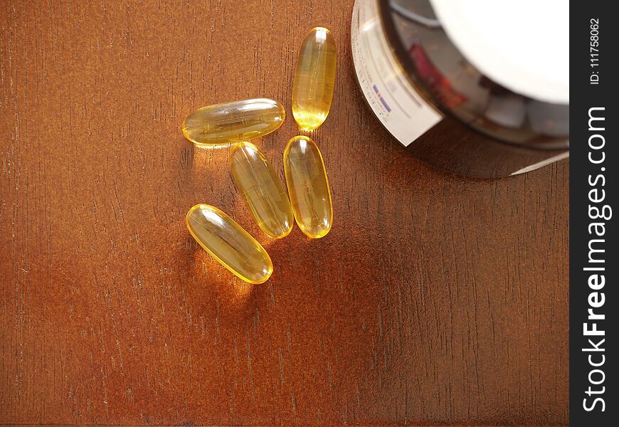 Vitamin Capsules on wood background, Gel vitamin