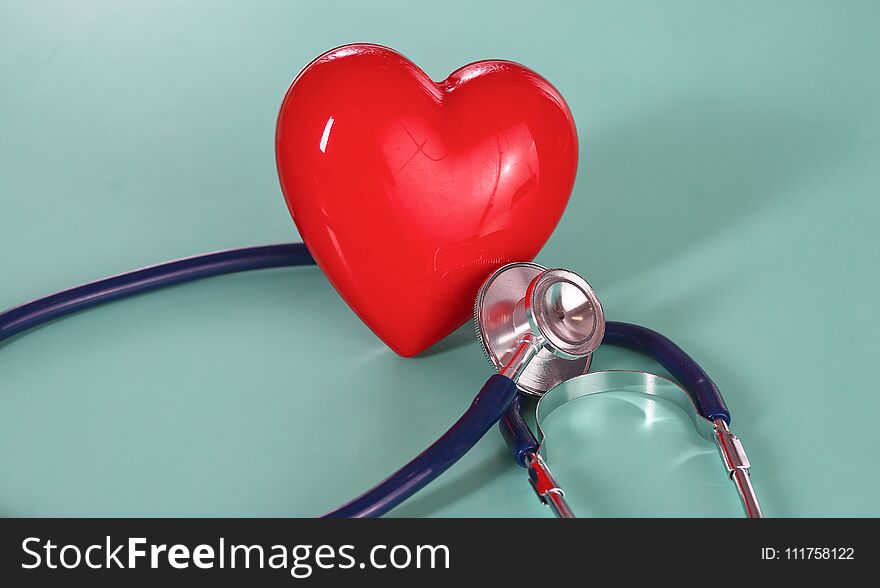 Red heart with stethoscope on blue wooden background. Copy space. Valentines day.