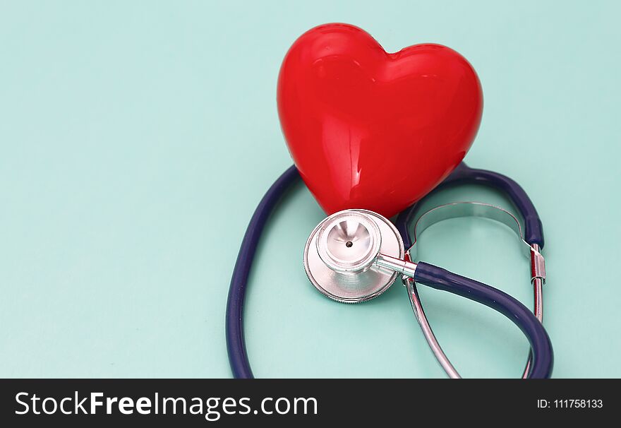 Red heart with stethoscope on blue wooden background. Copy space. Valentines day.