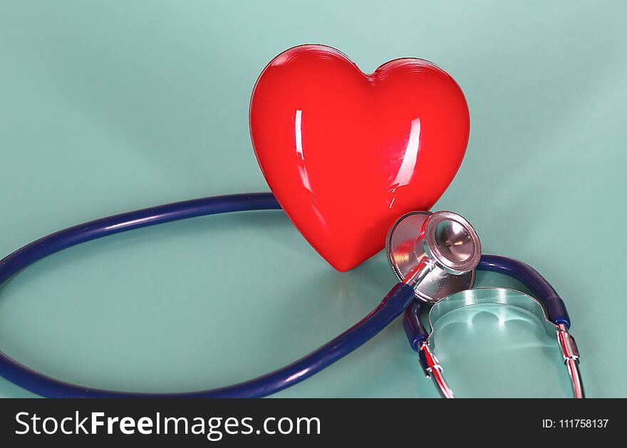 Red heart with stethoscope on blue wooden background. Copy space. Valentines day.