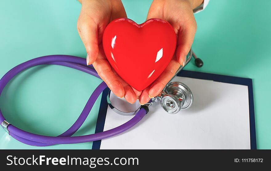 Female Doctor With The Stethoscope Holding Heart