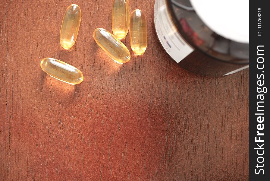 Vitamin Capsules on wood isolated background, Gel vitamin