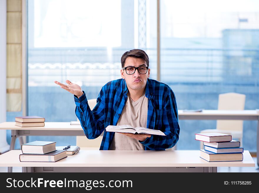 Student studying in the empty library with book preparing for ex