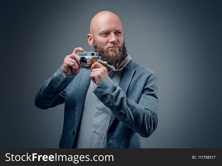 Hairless bearded male shooting with vintage SLR photo camera. Hairless bearded male shooting with vintage SLR photo camera.