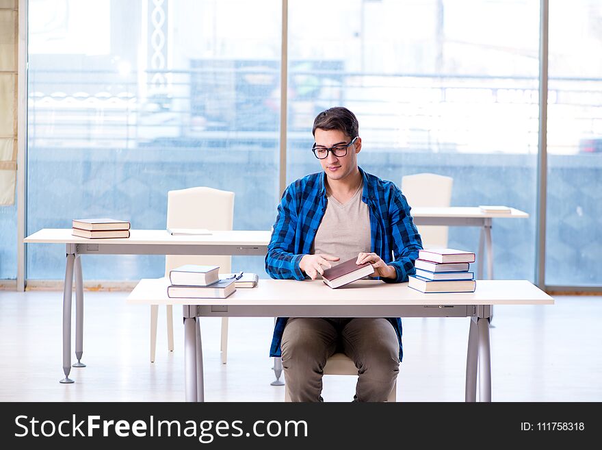 Student studying in the empty library with book preparing for ex