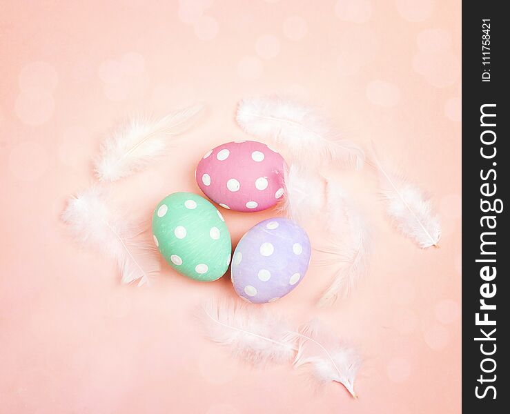 Colored Easter Eggs With Feathers On Pink Background.