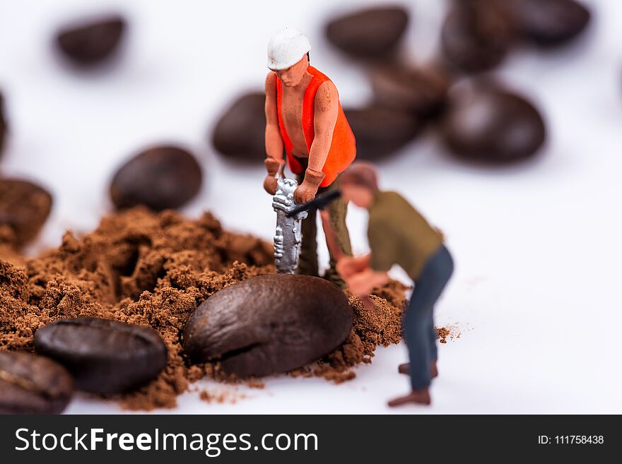 Miniature figures working on coffee macro photography on white background