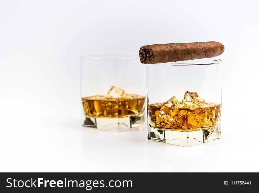 Whisky or whiskey or bourbon with ice and cigar on white background. Whisky or whiskey or bourbon with ice and cigar on white background