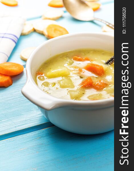 Homemade vegetables with carrot soup on blue wood table. Homemade vegetables with carrot soup on blue wood table