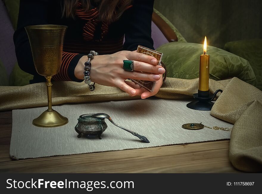 Tarot cards on fortune teller desk table. Future reading. Woman fortune teller holding in hands a deck of tarot cards and shuffles it. Tarot cards on fortune teller desk table. Future reading. Woman fortune teller holding in hands a deck of tarot cards and shuffles it.