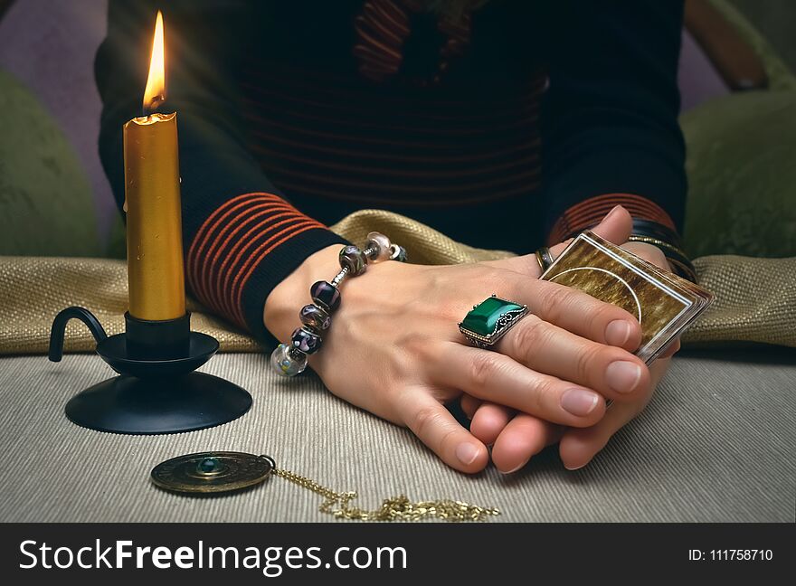 Tarot cards on fortune teller desk table. Future reading. Woman fortune teller holding and hands a deck of tarot cards and shuffles it. Tarot cards on fortune teller desk table. Future reading. Woman fortune teller holding and hands a deck of tarot cards and shuffles it.