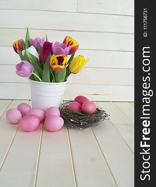 Easter. Pink Easter Eggs And Tulips Lie On A Wooden Background. Flat Lay.