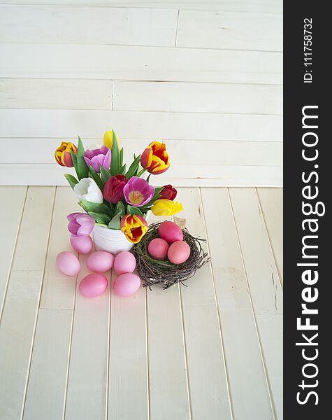 Easter. Pink easter eggs and tulips lie on a wooden background. Flat lay.