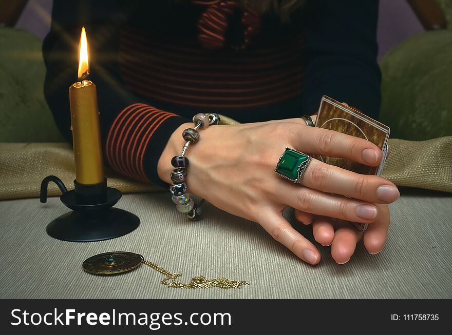 Tarot cards on fortune teller desk table. Future reading. Woman fortune teller holding in hands a deck of tarot cards and shuffles it. Tarot cards on fortune teller desk table. Future reading. Woman fortune teller holding in hands a deck of tarot cards and shuffles it.