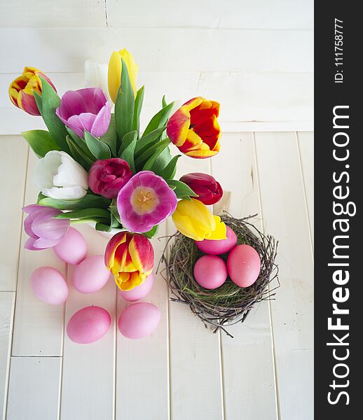 Easter. Pink easter eggs and tulips lie on a wooden background. Flat lay. Bird`s Nest. March 8. Pastel shades of pink. Wooden background. Conceptual photo. St. Patrick`s Day. Easter pink rabbit.
