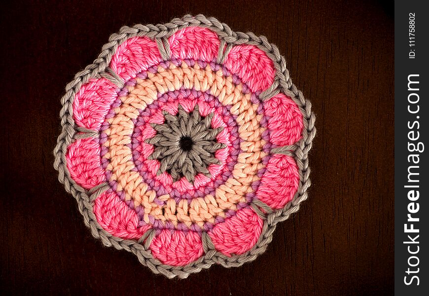 Knitting saucer, crochet work on the table, Top view of pink yarn