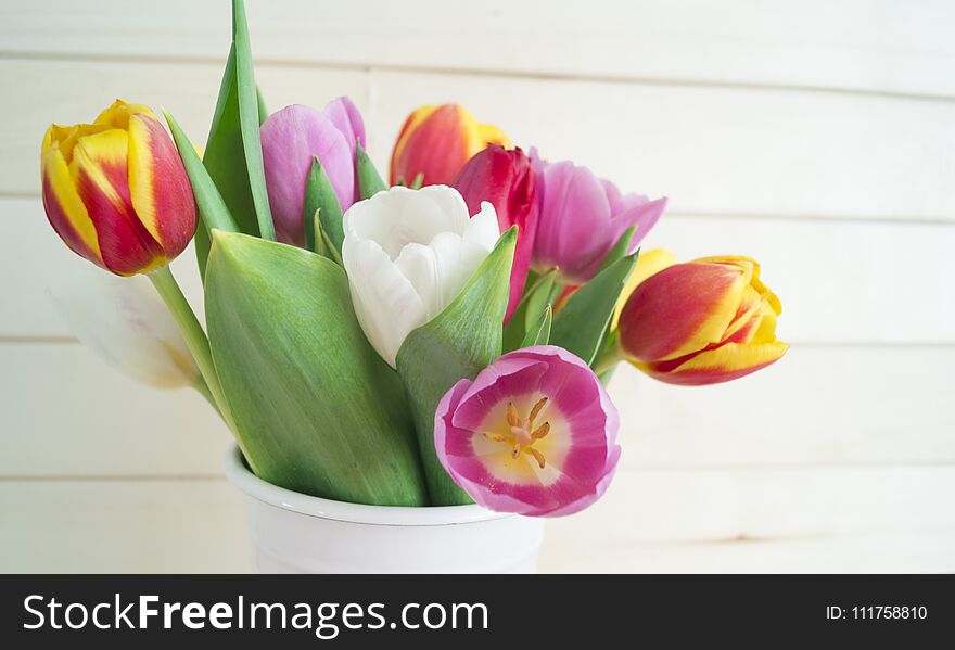 Easter. Pink easter eggs and tulips lie on a wooden background. Flat lay.