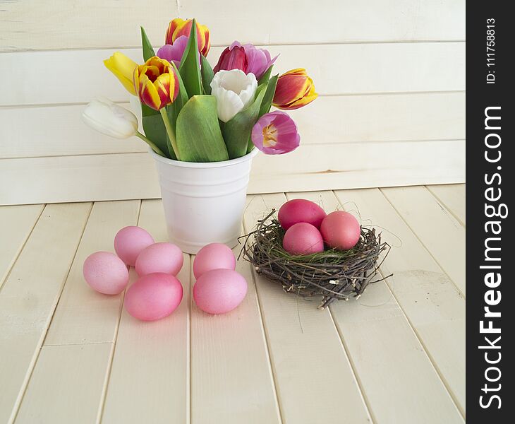 Easter. Pink easter eggs and tulips lie on a wooden background. Flat lay. Bird`s Nest. March 8. Pastel shades of pink. Wooden background. Conceptual photo. St. Patrick`s Day. Easter pink rabbit.
