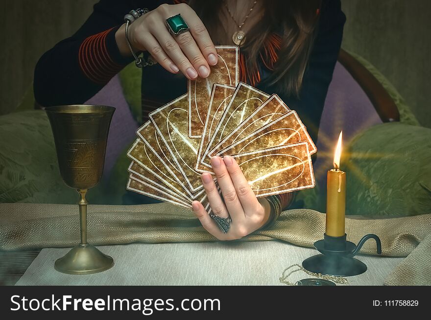 Tarot cards on fortune teller desk table. Future reading. Woman fortune teller holding and hands a deck of tarot cards. Tarot cards on fortune teller desk table. Future reading. Woman fortune teller holding and hands a deck of tarot cards.