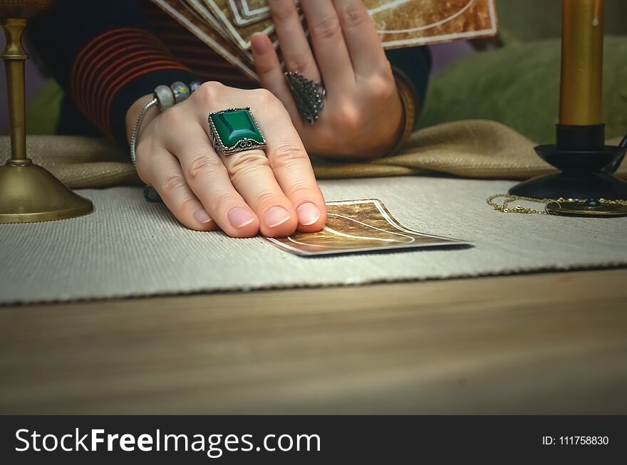 Tarot cards on fortune teller desk table. Future reading. Woman fortune teller holding and hands a deck of tarot cards. Tarot cards on fortune teller desk table. Future reading. Woman fortune teller holding and hands a deck of tarot cards.