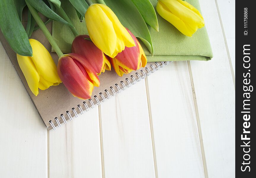 Tulips are yellow and orange. Wooden background. Spring flowers.