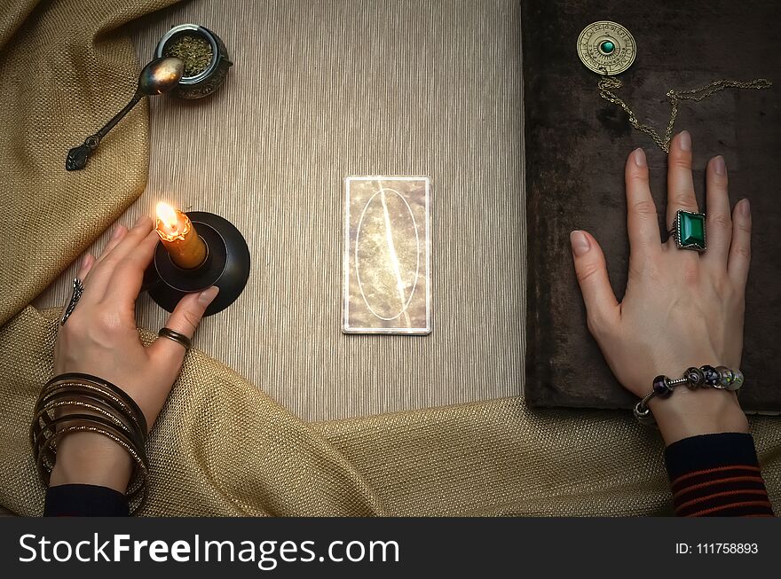 Book of magic. Tarot cards on fortune teller desk table. Future reading. Woman witch reads a ancient magic scroll book and learn art of prediction on wooden table. Book of magic. Tarot cards on fortune teller desk table. Future reading. Woman witch reads a ancient magic scroll book and learn art of prediction on wooden table.