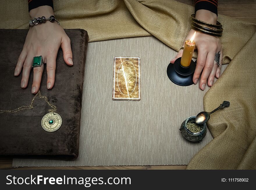 Book of magic. Tarot cards on fortune teller desk table. Future reading. Woman witch reads a ancient magic scroll book and learn art of prediction. Book of magic. Tarot cards on fortune teller desk table. Future reading. Woman witch reads a ancient magic scroll book and learn art of prediction.