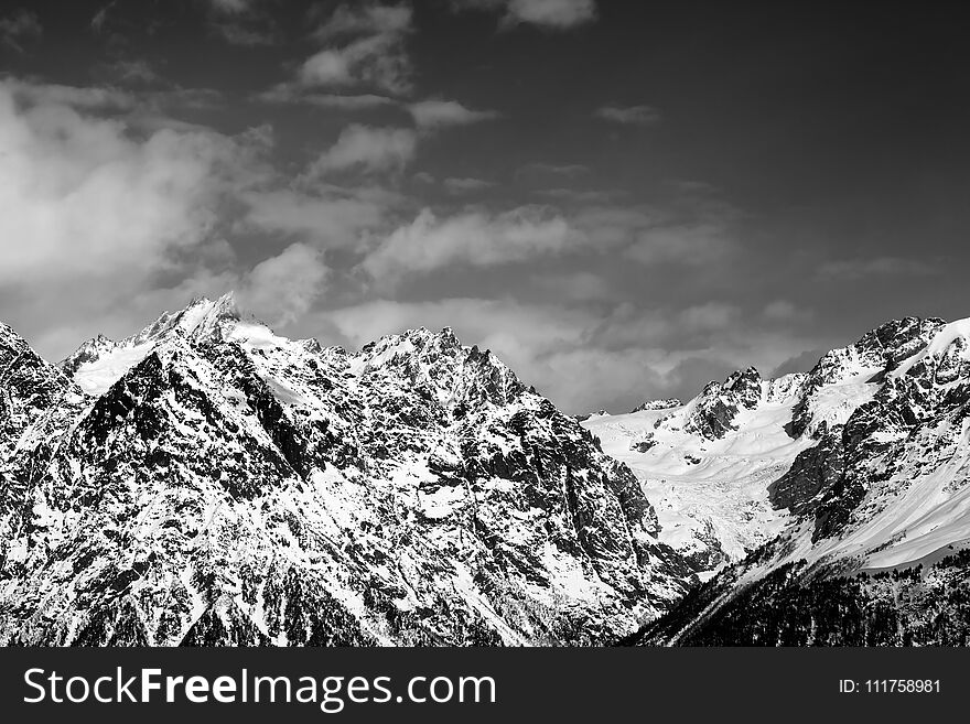 Snowy rocks at sunny day. View from chair lift on Hatsvali, Svaneti region of Georgia. Caucasus Mountains. Black and white toned landscape