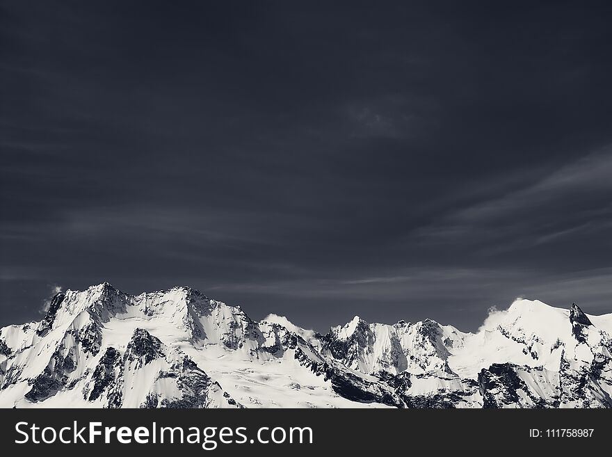 Winter snowy mountains in cold sunny day. Caucasus Mountains, region Dombay. Black and white. Toned landscape.