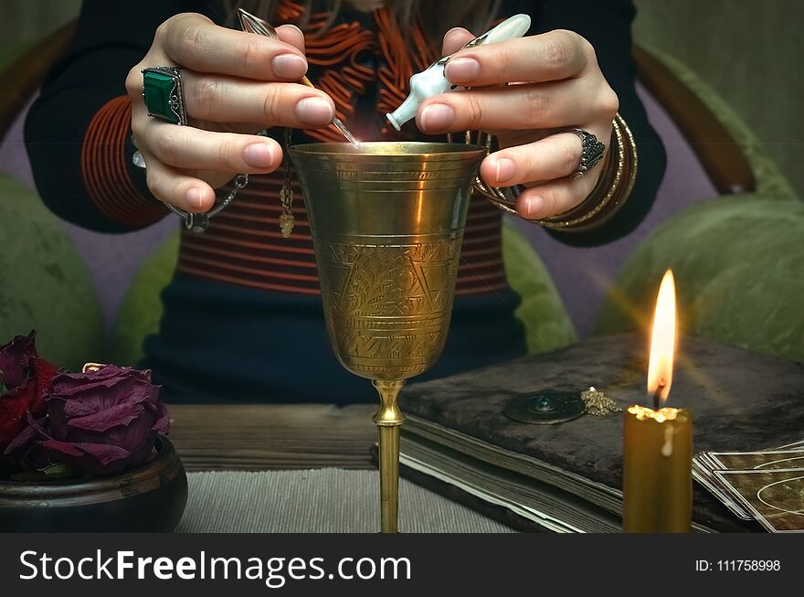 Woman witch prepare a magic potion. Future reading. Tarot cards on fortune teller desk table. Woman witch prepare a magic potion. Future reading. Tarot cards on fortune teller desk table.