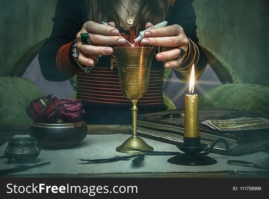 Woman witch prepare a magic potion. Future reading. Tarot cards on fortune teller desk table. Woman witch prepare a magic potion. Future reading. Tarot cards on fortune teller desk table.