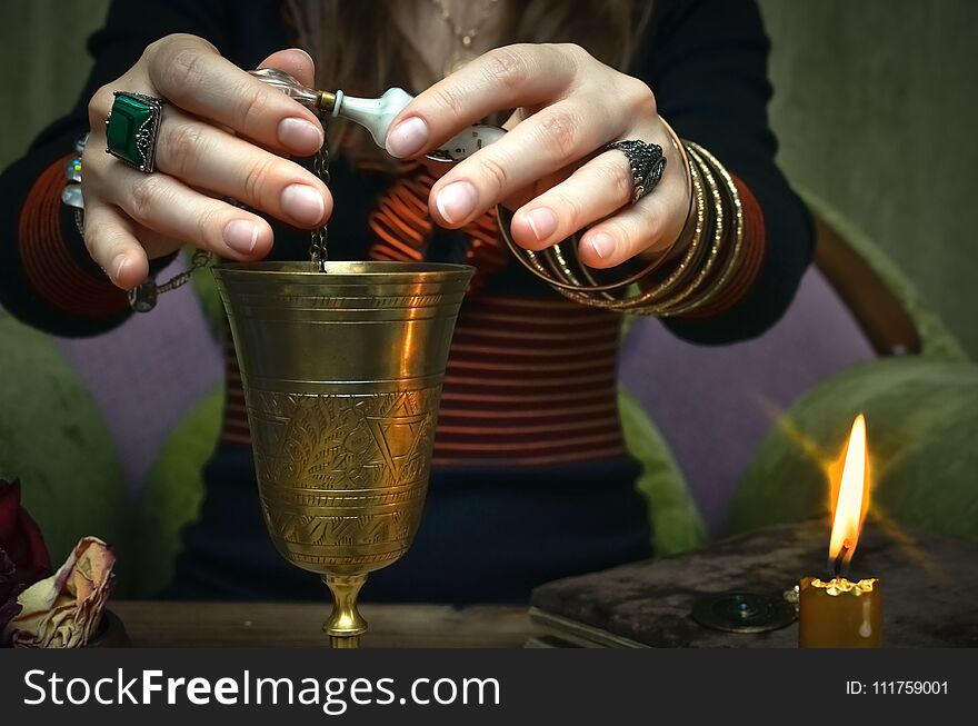 Woman witch prepare a magic potion. Future reading. Tarot cards on fortune teller desk table. Woman witch prepare a magic potion. Future reading. Tarot cards on fortune teller desk table.