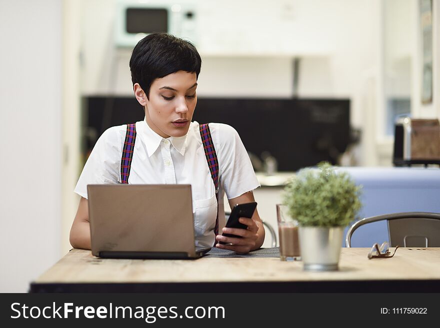 Young Businesswoman With Very Short Haircut Looking At Her Smart