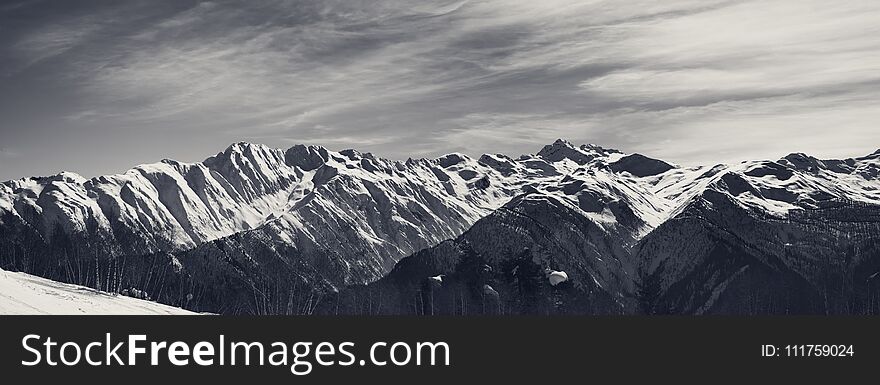 Panoramic view on sunlight snowy mountains in nice morning. Caucasus Mountains. Svaneti region of Georgia. Black and white toned landscape.