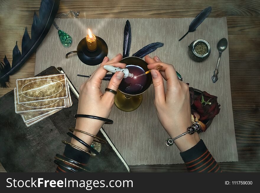 Woman witch prepare a magic potion. Future reading. Tarot cards on fortune teller desk table. Woman witch prepare a magic potion. Future reading. Tarot cards on fortune teller desk table.