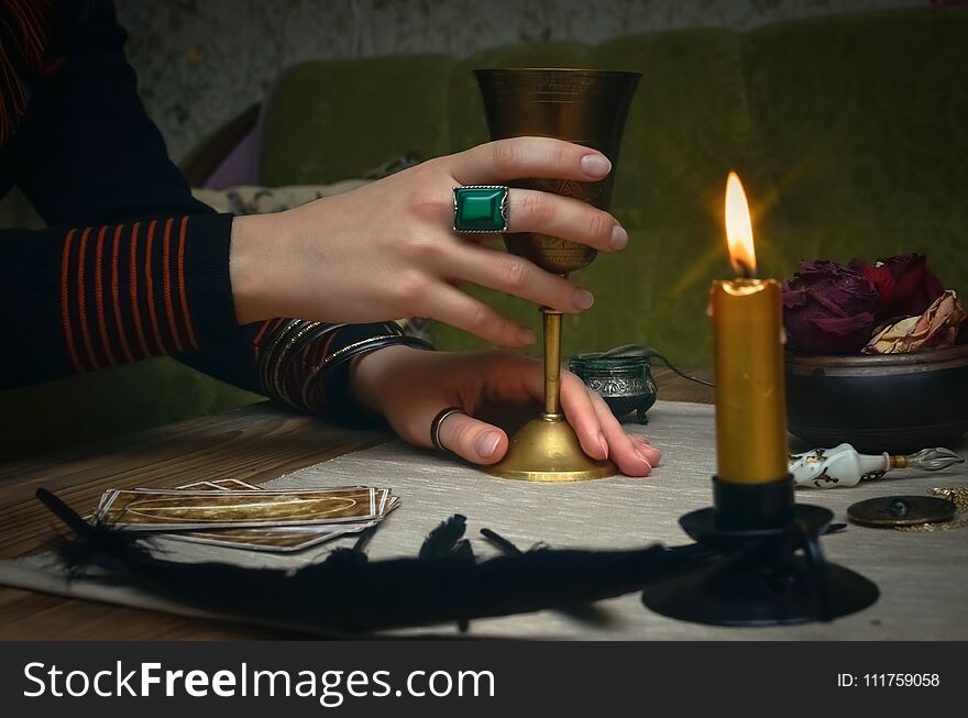 Woman witch prepare a magic potion. Future reading. Tarot cards on fortune teller desk table. Woman witch prepare a magic potion. Future reading. Tarot cards on fortune teller desk table.