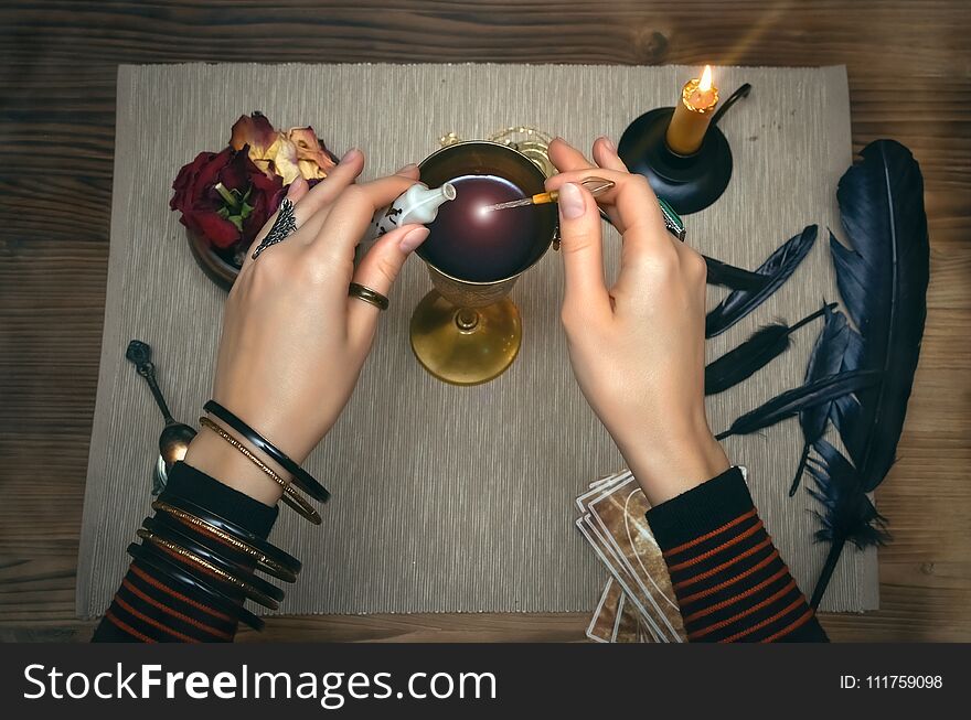 Woman witch prepare a magic potion. Future reading. Tarot cards on fortune teller desk table. Woman witch prepare a magic potion. Future reading. Tarot cards on fortune teller desk table.