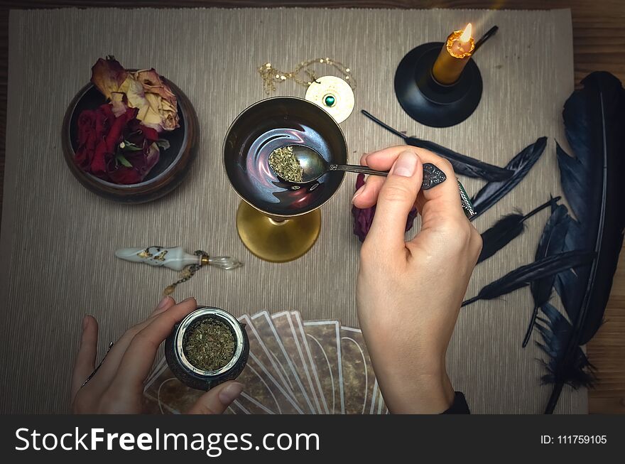 Woman witch prepare a magic potion. Future reading. Tarot cards on fortune teller desk table. Woman witch prepare a magic potion. Future reading. Tarot cards on fortune teller desk table.