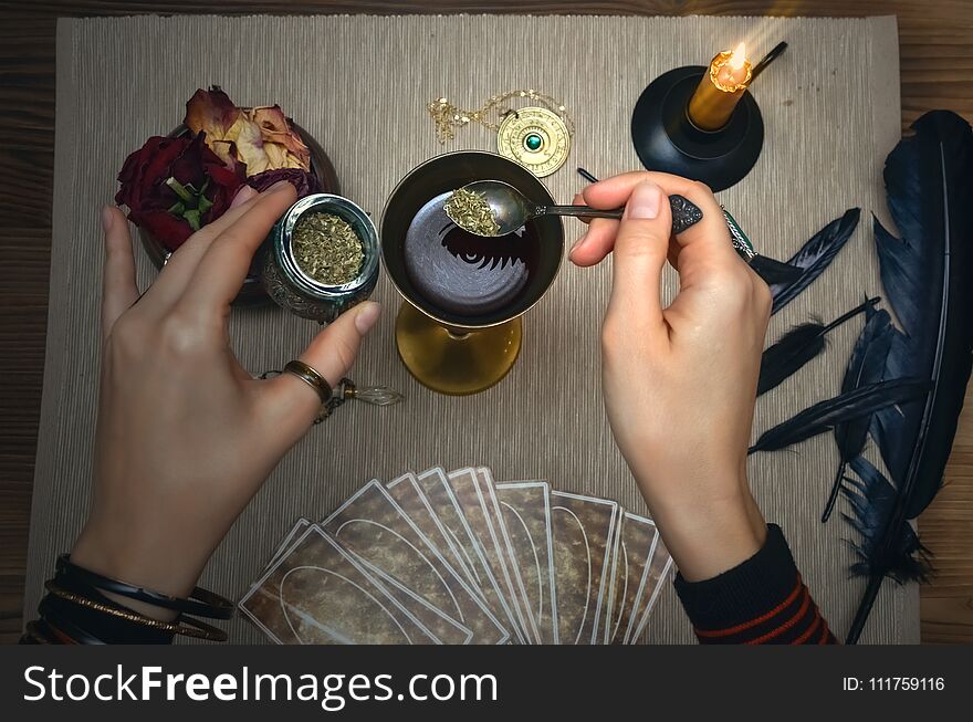 Woman witch prepare a magic potion. Future reading. Tarot cards on fortune teller desk table. Woman witch prepare a magic potion. Future reading. Tarot cards on fortune teller desk table.