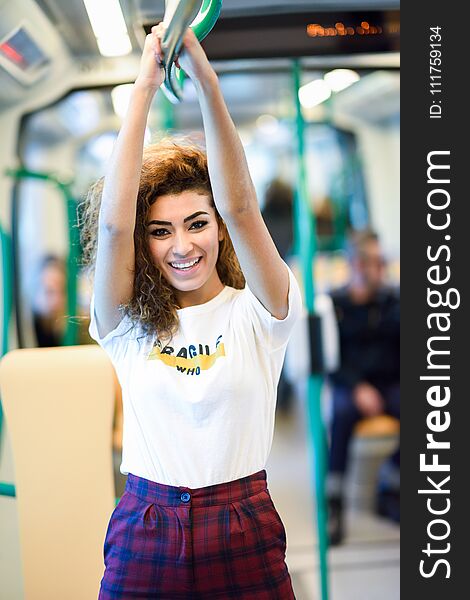 Arabic woman inside subway train. Arab girl in casual clothes smiling in the metro. Arabic woman inside subway train. Arab girl in casual clothes smiling in the metro.