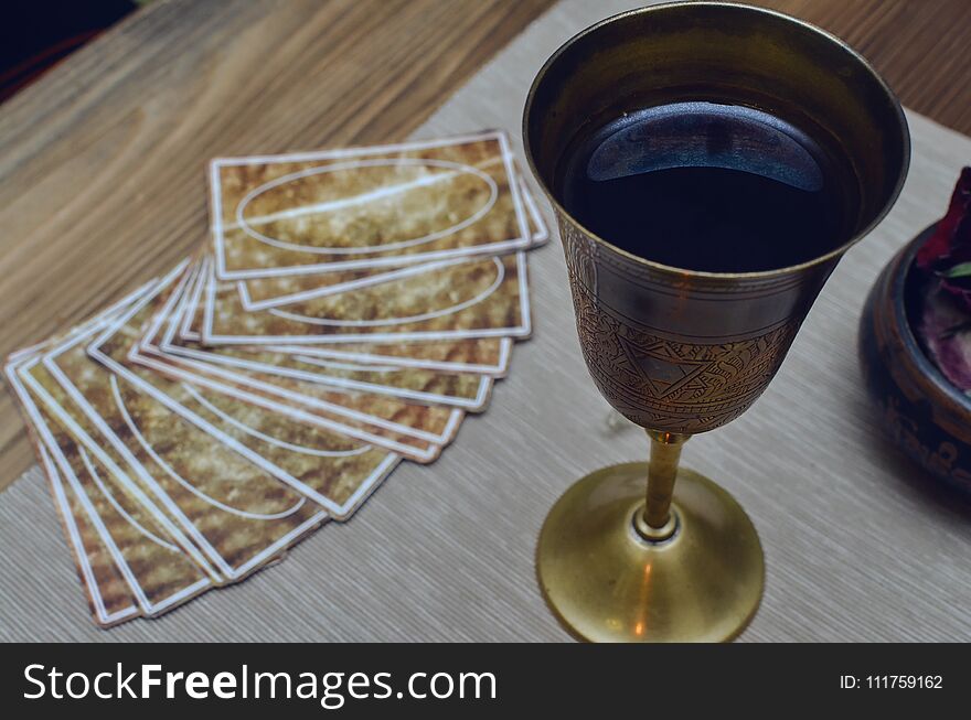 Tarot cards on fortune teller desk table and wine goblet. Tarot cards on fortune teller desk table and wine goblet.