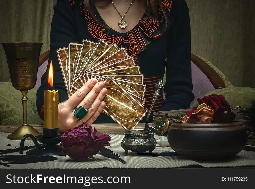 Tarot cards on fortune teller desk table. Future reading. Woman fortune teller holding and hands a deck of tarot cards. Tarot cards on fortune teller desk table. Future reading. Woman fortune teller holding and hands a deck of tarot cards.