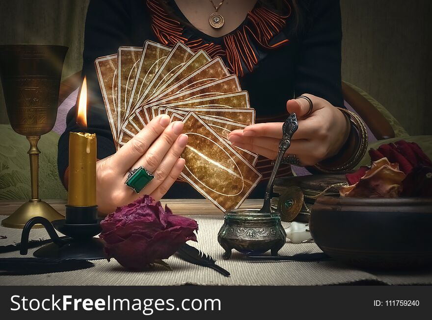 Tarot cards. Future reading. Woman fortune teller holding in hands a deck of tarot cards and shows on it. Tarot cards. Future reading. Woman fortune teller holding in hands a deck of tarot cards and shows on it.