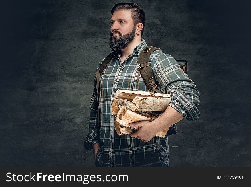 Fat bearded male holds fire woods over grey background. Fat bearded male holds fire woods over grey background.